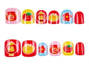 Primer plano detallado de uñas postizas coloridas para niños con motivos festivos.