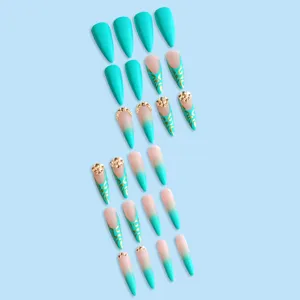 Uñas postizas almendradas largas con degradado azul-verde, patrones dorados y pedrería.