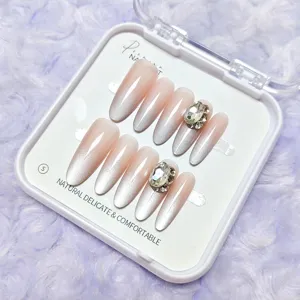 Detalle de uñas postizas press-on degradado rosa nude efecto ojo de gato con brillantes pedrería