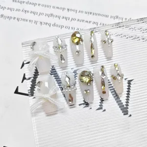 Uñas postizas largas con lazos blancos elegantes, pedrería brillante y perlas. Set 10 pz.