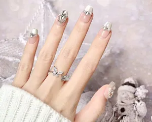Uñas postizas hechas a mano con pedrería brillante y elegante anillo de mariposa.