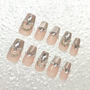 Juego de uñas postizas hechas a mano con brillo cat-eye y decoración de pedrería.