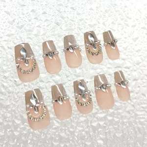 Uñas postizas hechas a mano con efecto ojo de gato, purpurina y pedrería de brillantes detalles.