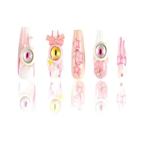 Unghie finte fatte a mano con simpatici occhi di mostro e fiocchi rosa, perfette per look alla moda.