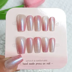 Detalle de uñas postizas hechas a mano con degradado rosa efecto ojo de gato brillante.