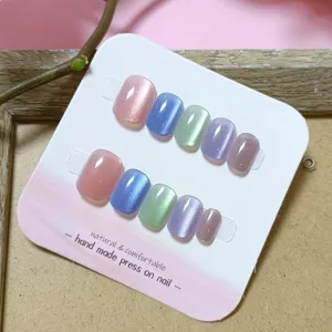 Vista detallada del juego de uñas postizas hechas a mano con efecto ojo de gato.
