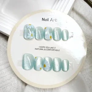 Uñas postizas hechas a mano con efecto ojo de gato y bonito diseño de margarita blanca.