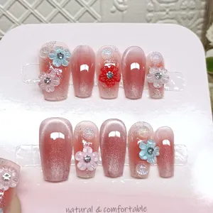 Uñas postizas hechas a mano con degradado rosa efecto ojo de gato y pedrería brillante.