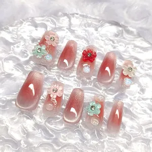 Detalle de uñas postizas cortas hechas a mano, diseño degradado de flor de cerezo