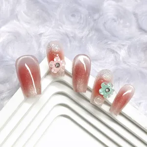 Uñas postizas cortas hechas a mano con degradado blush rosa, brillo cat-eye y flores 3D.