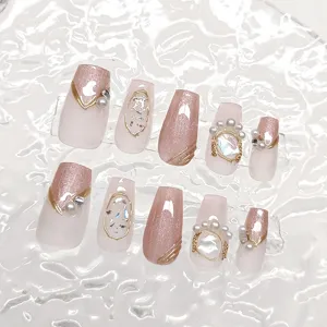 Detalle de uñas postizas hechas a mano, efecto ojo de gato, perlas y pedrería.