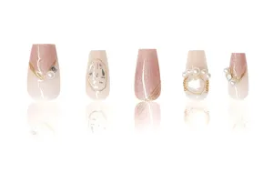 Primer plano de uñas postizas de lujo con perlas, estrás, efecto ojo de gato y hoja de oro.