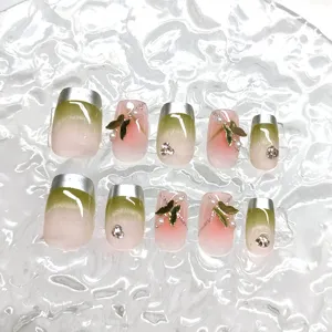 Vista detallada de 10 uñas postizas hechas a mano con degradado verde y mariposas.