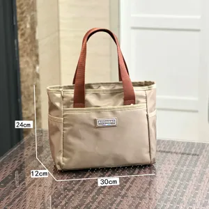 Detailed view of beige commuter tote bag with brown handles and dimension labels.