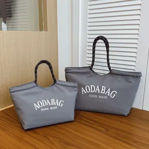 Grijze canvas shopper tassen met touw handvatten en print, ideaal voor dagelijks gebruik en werk.