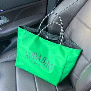 Green tote bag with black white rope handles detail view for commuting and shopping daily use.