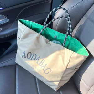 Detail shot of minimalist khaki canvas tote bag with vibrant green inner lining and handles.