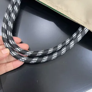 Close-up detail of the durable woven checkered tote bag handle showing fine texture.