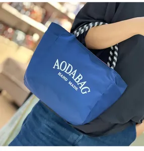 Blue canvas tote bag with black and white striped handles, large capacity casual shoulder bag.