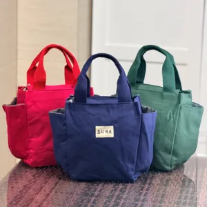 Canvas lunch bag detail showcasing durable material, multiple colors and handy side pockets.