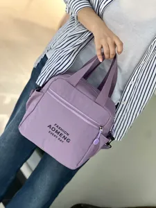 Detailed view of the purple insulated lunch bag showing the convenient front zipper pocket and handles.