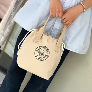 Detailed view of the waterproof drawstring lunch bag with handle and cute bear print.