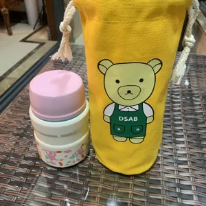 Vue détaillée du sac cordon en toile jaune motif dessin animé ours et de sa housse thermos.