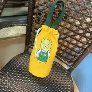 Vue détaillée du sac gourde en toile motif dessin animé avec cordon et poignée verte.