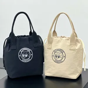 Detail view of waterproof canvas drawstring tote lunch bag with dual handles and bear logo.