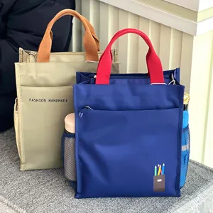 Detail view of multi-layer canvas tote bag with side mesh pockets and vibrant color handles.