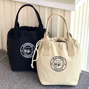 Detailed view of waterproof canvas drawstring lunch bucket bag with cute bear logo print.