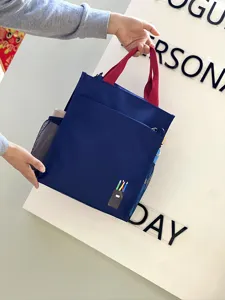 Blue multi-layer student tote bag with red handles and pencil graphic for daily commuting.