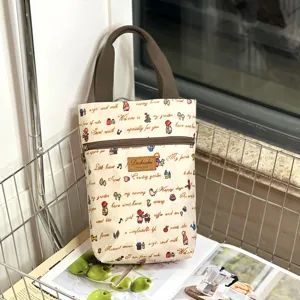 Waterproof cartoon canvas handbag with zipper pocket and sturdy brown handles for daily use.