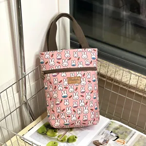 Detailed view of the pink cartoon rabbit print waterproof handbag with secure zipper and straps.