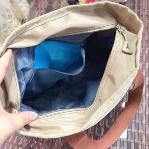 Interior detail view of the commuter handbag featuring blue lining and zip pocket.