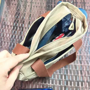 Detailed view of the multi-compartment handbag interior, showing organized storage and zippers.