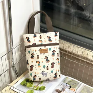 Cute cartoon dog print waterproof canvas handbag detail view with durable brown fabric handles.