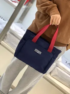 Canvas tote bag featuring red handles, contrast color design for daily commute and casual use.