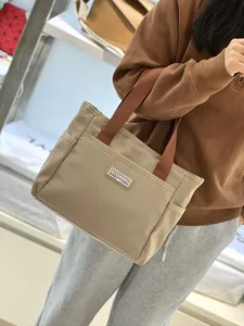 Casual khaki canvas tote bag with brown straps and multi-pockets for daily work commute.