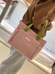 Korean style color contrast canvas handbag with green handles, casual tote bag for work and commute.