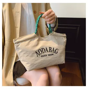 Casual beige canvas tote tas met groene touw handgrepen en letterprint voor dagelijks.
