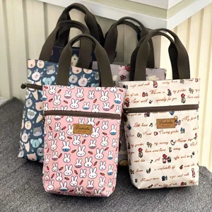 Detailed view of waterproof canvas tote bags featuring cute cartoon rabbit and floral print designs.