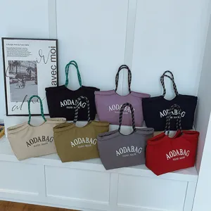 Gedetailleerd overzicht van grote canvas tote bags in diverse kleuren met handvatten.