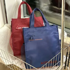 Large canvas tote bag with side mesh pockets and front zippered pocket for daily use.