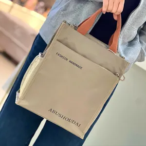 Detailed view of the multi-layer thickened tote bag with mesh pockets and contrast color handle.