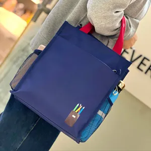 Blue multi-layer student tote bag with red handles, side mesh pockets and front pencil print