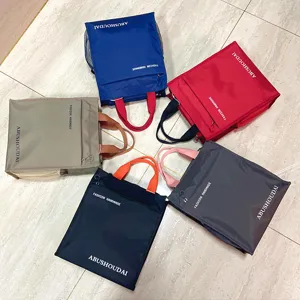 Details of the multi-layer colorblocked tote bag, featuring sturdy handles and pockets.