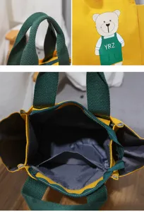 Canvas bento handtas detailweergave met stevige groene handvatten en binnenzak.