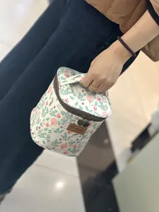 Close-up detail of the cute rabbit floral lunch cosmetic bag with sturdy handle and zipper.