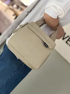 Beige waterproof lunch tote bag detail, minimalist commuter bento handbag handle view.